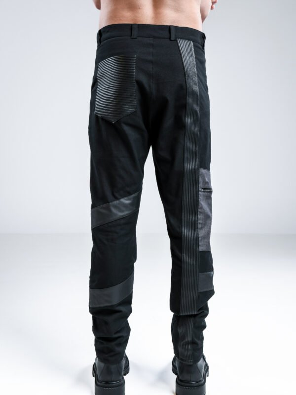 Black Vault Pants by Kali Rose featuring grey panels, faux leather stripes, multiple pockets and a decorative knee zipper, front and back views.
