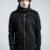 Black men's longline hoodie with high collar, front zipper, thumbholes and architectural pinch-stitch details, front and back views.