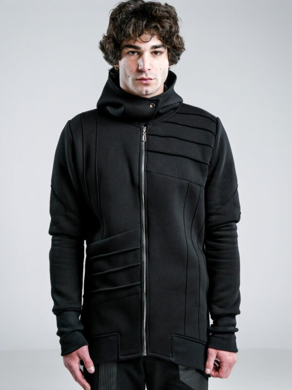 Black men's longline hoodie with high collar, front zipper, thumbholes and architectural pinch-stitch details, front and back views.