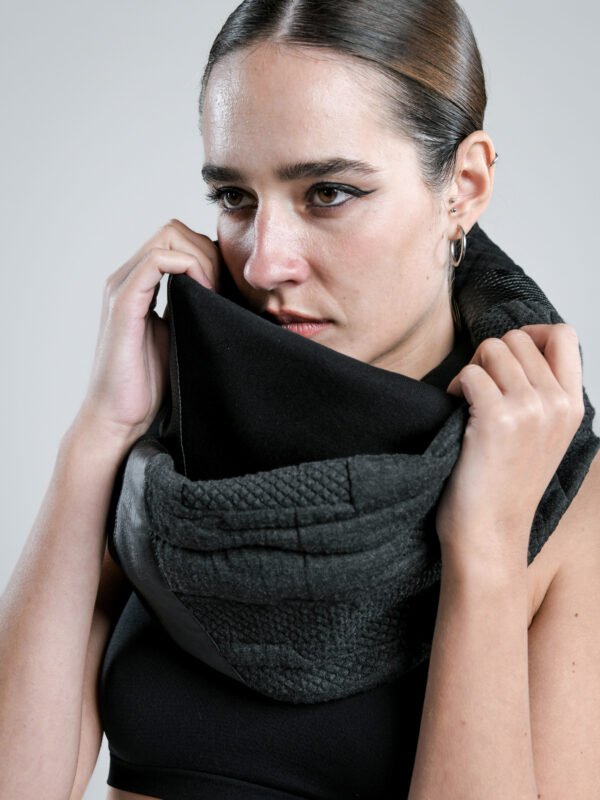 Axiom black wrap scarf worn by a woman, featuring layered cotton textures and faux-leather detailing.